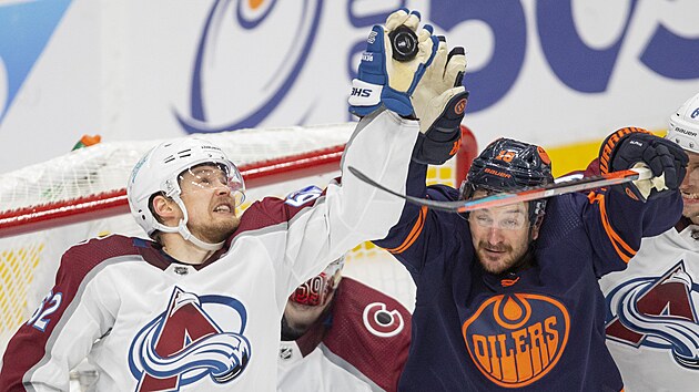 Artturi Lehkonen (vlevo) z Colorado Avalanche stahuje puk v zpase s Edmonton Oilers, Zach Hyman na doskoku neuspl.