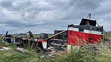 Zničenou tramvaj, která stála na poli u dálnice D1, nový majitel rozřezává na...