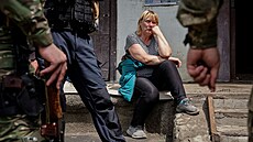 Obyvatelka msta Lysyansk na severu Donbasu pozoruje okolo stojící policisty....