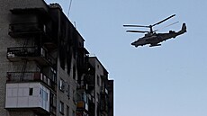 Ruský vrtulník Kamov Ka-52 Alligator prolétá kolem obytné budovy ve mst...