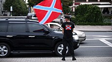 Proruský separatista drí vlajku Novoruska u demonstrace za jeho podporu, která...