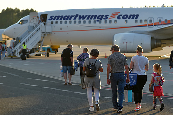 Cestující nastupují do letadla pravidelné linky mezi letitm v Karlových...