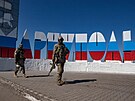 Vojáci prochází kolem nového cedule s názvem msta v barvách ruské vlajky u...