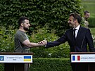 Ukrajinský prezident Volodomyr Zelenskyj si podává ruce s francouzským...