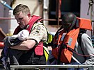 Voják nese dít migrant, které pivezly pohraniní síly do anglického Doveru....