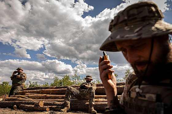 Ukrajinský voják na Donbasu naslouchá rozkazům z vysílačky. (20. května 2022)