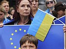 Lidé drí vlajky EU a Ukrajiny bhem shromádní v Bruselu. (23. ervna 2022)