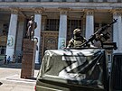 Ruský voják hlídkuje u budovy filhamonie v ukrajinském Mariupolu. (12. ervna...