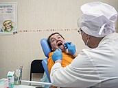 Zubař ošetřuje ženu v pečovatelském domě pro seniory ve vesnici Dachnoje v...