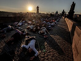 Několik stovek lidí si přišlo v den slunovratu za východu slunce zacvičit jógu...