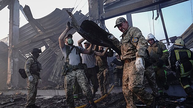 Ukrajinští hasiči hledají přeživší v obchodním centru v Kremenčuku, které zasáhly ruské rakety. (28. června 2022)
