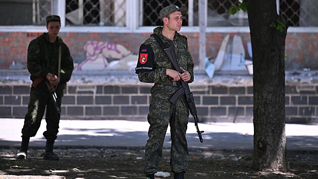 Rusové kontrolují každého, kdo ještě ve zničeném Mariupolu na Ukrajině zůstal. Na snímku jsou policisté doněckých separatistů. (12. června 2022)