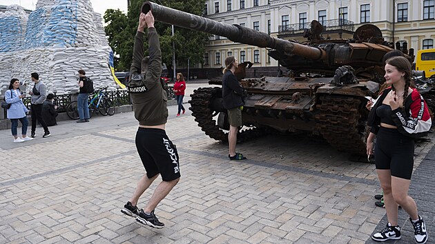 Mlad Ukrajinci se fot u zniench ruskch tank v centru Kyjeva. (27. kvtna 2022)