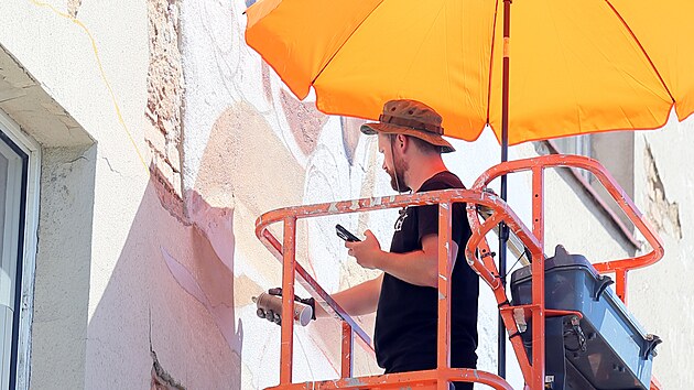 Umlec Chemis pracuje na svm obrazu na zdi pavlaovho domu v Jaten ulici v Plzni. (15. 6. 2022)