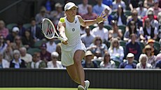 Iga wiateková se natahuje po balonku v utkání prvního kola Wimbledonu.