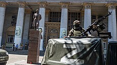 Ruský voják hlídkuje u budovy filhamonie v ukrajinském Mariupolu. Členové...
