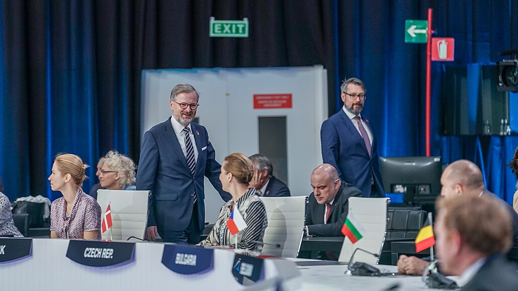 Premiér Petr Fiala na summitu NATO v Madridu. V pozadí eský vyslanec u Aliance...