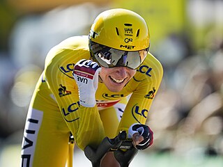Tadej Pogačar projíždí s úsměvem cílem dvacáté etapy Tour de France.