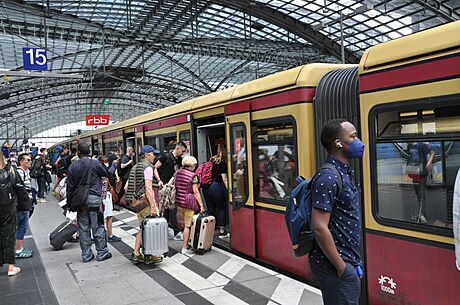 Cestující ekají na nástupiti vlakového nádraí v Berlín (30. ervna 2022)