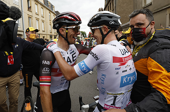 Slovinský cyklista Tadej Pogaar v bílém dresu se raduje s týmovým kolegou z...