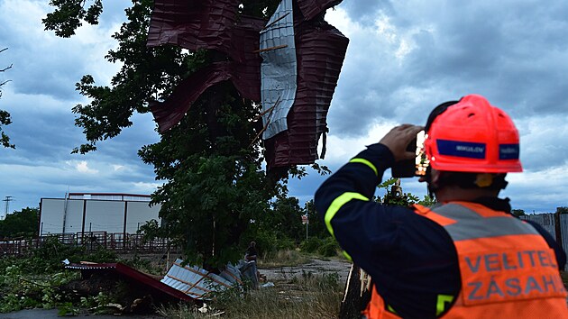 Bouřková fronta, která v pátek večer přešla přes jih Moravy, za sebou zanechala polámané stromy i poškozené střechy. Na snímku hasiči zasahují ve Valticích na Břeclavsku. (1. července 2022)