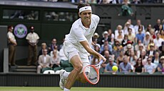 Amerian Taylor Fritz se natahuje po balonku ve tvrtfinále Wimbledonu.