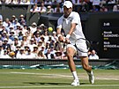 Novak Djokovi se rovná k bekhendovému úderu ve finále Wimbledonu.