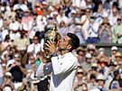 Novak Djokovi líbá trofej pro vítze Wimbledonu.