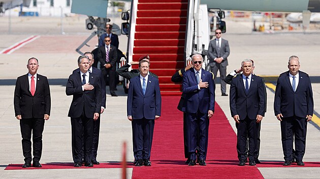 Americk prezident Joe Biden (uprosted) pi pjezdu do Izraele. Na letiti ho pivtali izraelsk prezident Jicchak Herzog (druh zleva), izraelsk premir Ja'ir Lapid (druh zprava) a tak bval premir Naftali Bennett (napravo). (13. ervence 2022)