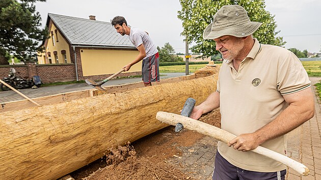 Archeolog Radomír Tichý ve Všestarech u Hradce Králové při výrobě pravěkého člunu ze 400 let starého kmenu dubu (1. července 2022)