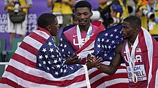 Vít�zný Fred Kerley (uprost�ed) se svými krajany a medailovými par�áky. Vlevo...