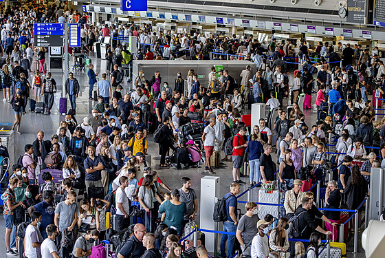 Cestující se svými zavazadly čekají na letišti během varovné stávky...