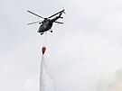 Vrtulník s bambi vakem hasí poár v NP eské výcarsko. (26. ervence 2022)