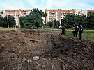 Policisté stojí u kráteru po granátech v rezidenní tvrti Charkova. (26....