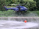 Vrtulník nabírá vodu z Labe, aby uhasil lesní poár v Národním parku Saské...