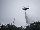 Policejní vrtulník pi práci na poáru v Národním parku eské výcarsko u...