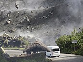 Balvany padající na silnici - následky silného zemětřesení vě městě Bauko ve...