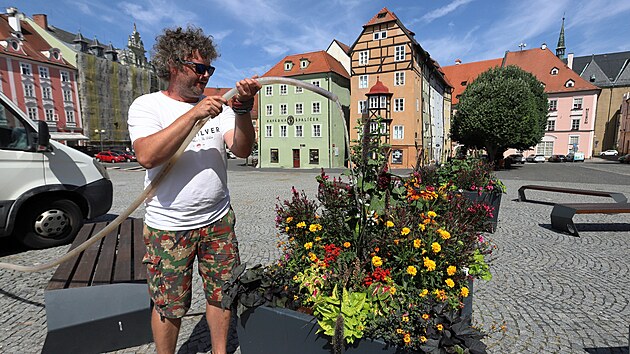 Zahradník zalévá mobilní zeleň na náměstí před chebským Špalíčkem.
