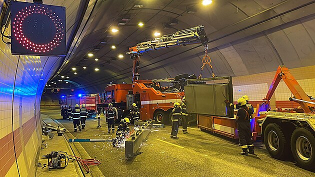 Hasiči v tunelu Mrázovka odklízejí směrovou ceduli, do které narazil kamion. (29. července 2022)