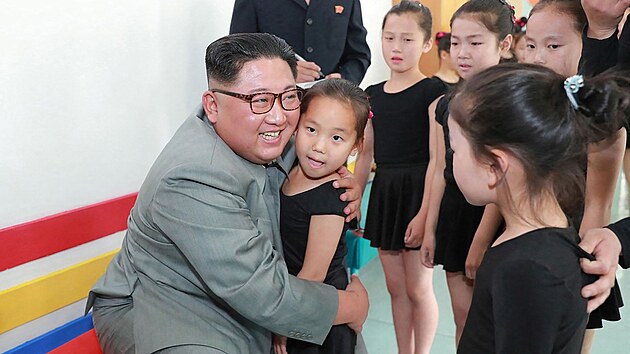 Vůdce KLDR Kim Čong-un objímá dívku během své návštěvy základní školy. (1. června 2019)