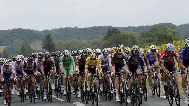 Jonas Vingegaard (ve lut) jede v pelotonu bhem 19. etapy Tour de France. Vedle nj jsou Wout van Aert (zelen) a Tadej Pogaar (bl).