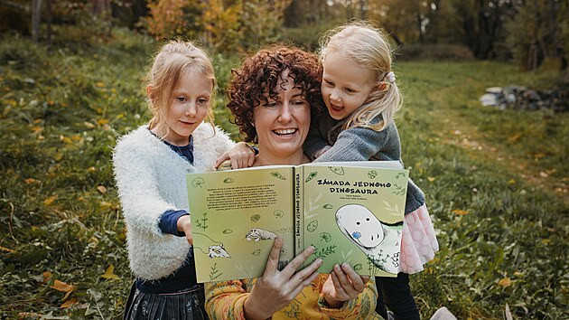 Autorka Lucie Rybová s dcerami a knihou Záhada jednoho dinosaura
