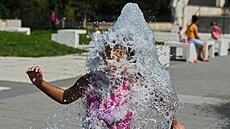 Děti se v horkém dni ochlazují u fontány na piazzettě před Janáčkovým divadlem...