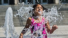 Děti se v horkém dni ochlazují u fontány na piazzettě před Janáčkovým divadlem...