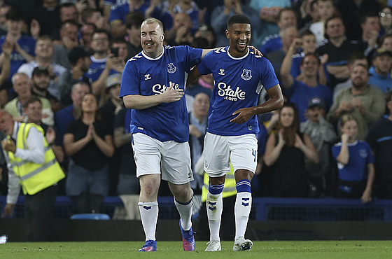 Obránce Mason Holgate (vpravo) a fanouek Evertonu Paul Stratton.