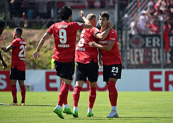 Spoluhrái z Leverkusenu gratulují Adamu Hlokovi k prvnímu soutnímu gólu v...