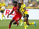 Obránce Bayeru Leverkusen Edmond Tapsoba v souboji s útoníkem Youssoufou...