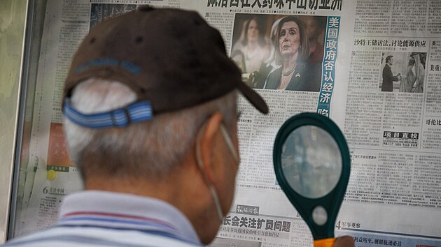 Muž v Pekingu čte zpravodajství o cestě Nancy Peloisové do Asie. (1. srpna 2022)