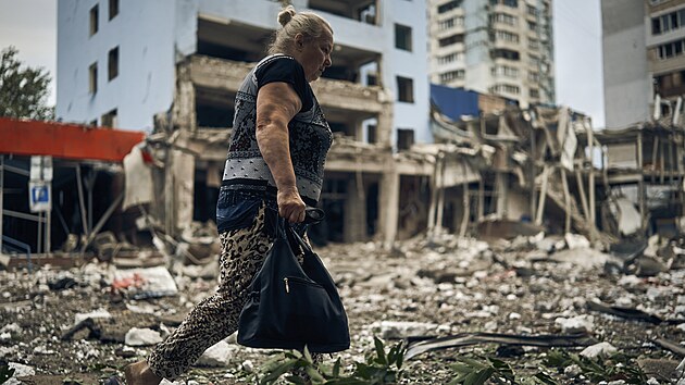 Ukrajinka prochází mezi troskami obytné budovy po nočním ostřelování v Mykolajivu na Ukrajině. (3. srpna 2022)