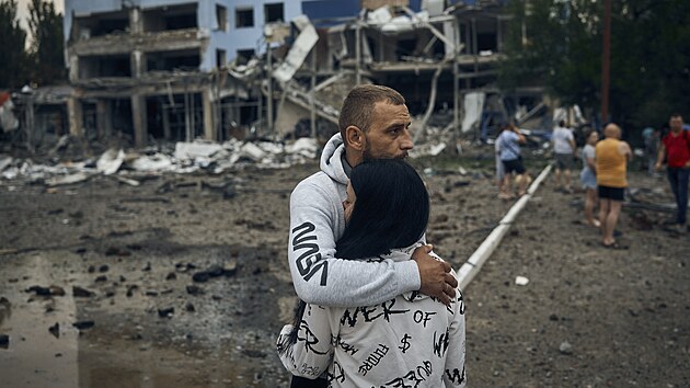 Ukrajinci mezi troskami obytn budovy po nonm ostelovn v Mykolajivu na Ukrajin. (3. srpna 2022)